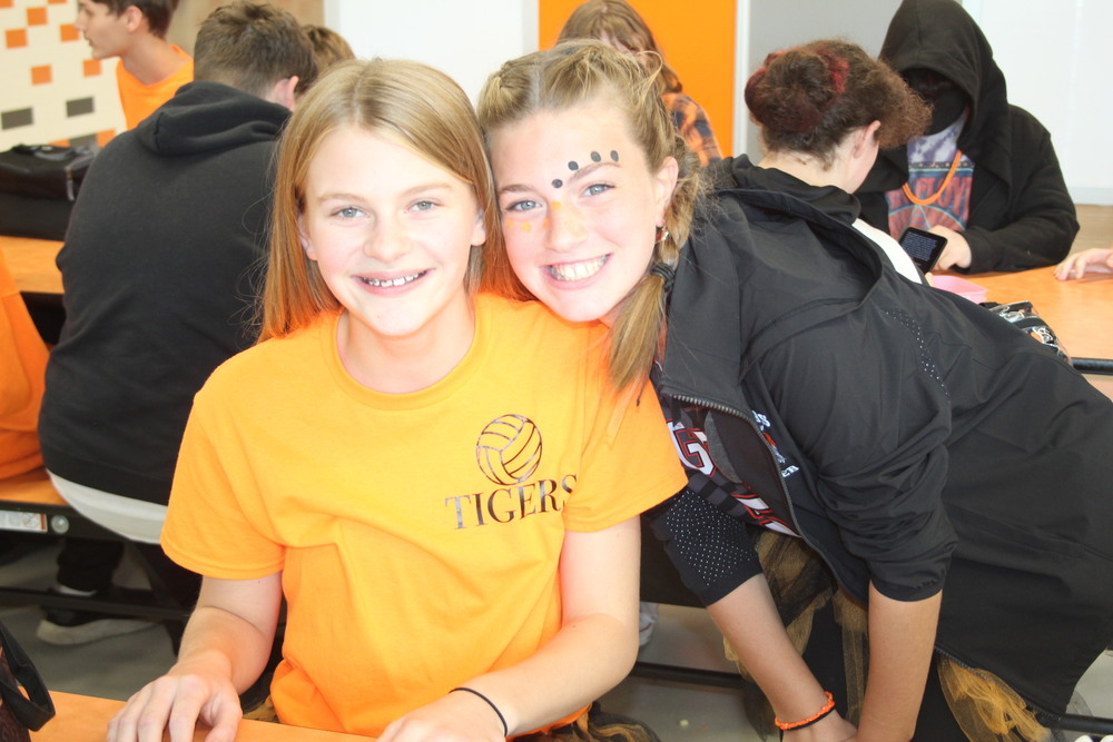 Two students in orange and black dressed for spirit week.